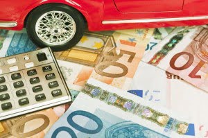 miniature car with bills and calculator