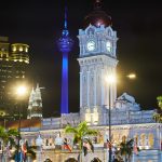 Illuminated Sultan Abdul Samad Building at night with Kuala Lumpur skyline and KL Tower in the background
