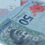 Close-up of Malaysian ringgit banknotes showing RM50 bills with security features and floral design