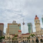 Kuala Lumpur skyline with Sultan Abdul Samad Building, Merdeka Square and KL Tower under cloudy sky, Malaysia cityscape