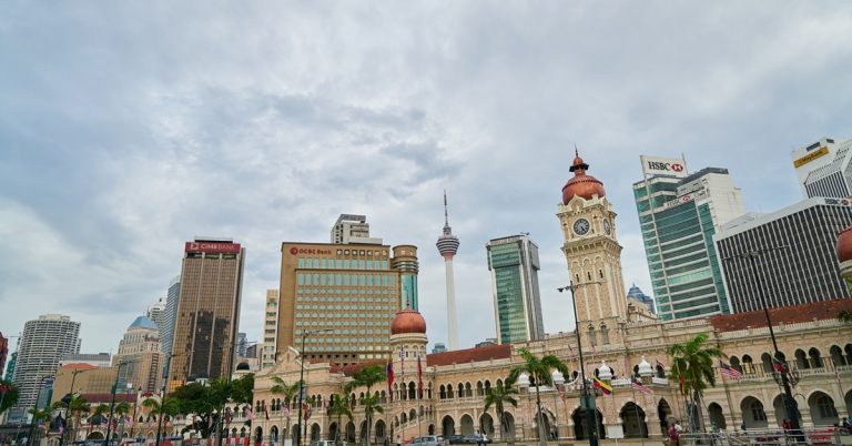 Kuala Lumpur skyline with Sultan Abdul Samad Building, Merdeka Square and KL Tower under cloudy sky, Malaysia cityscape