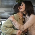 Young woman hugging elderly woman warmly indoors, showing affection, family bond, and emotional support between generations