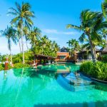 Luxury tropical resort with infinity pool, palm trees and beachfront villas, ideal for vacation travel and relaxation