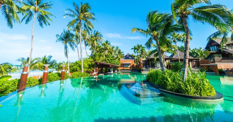 Luxury tropical resort with infinity pool, palm trees and beachfront villas, ideal for vacation travel and relaxation
